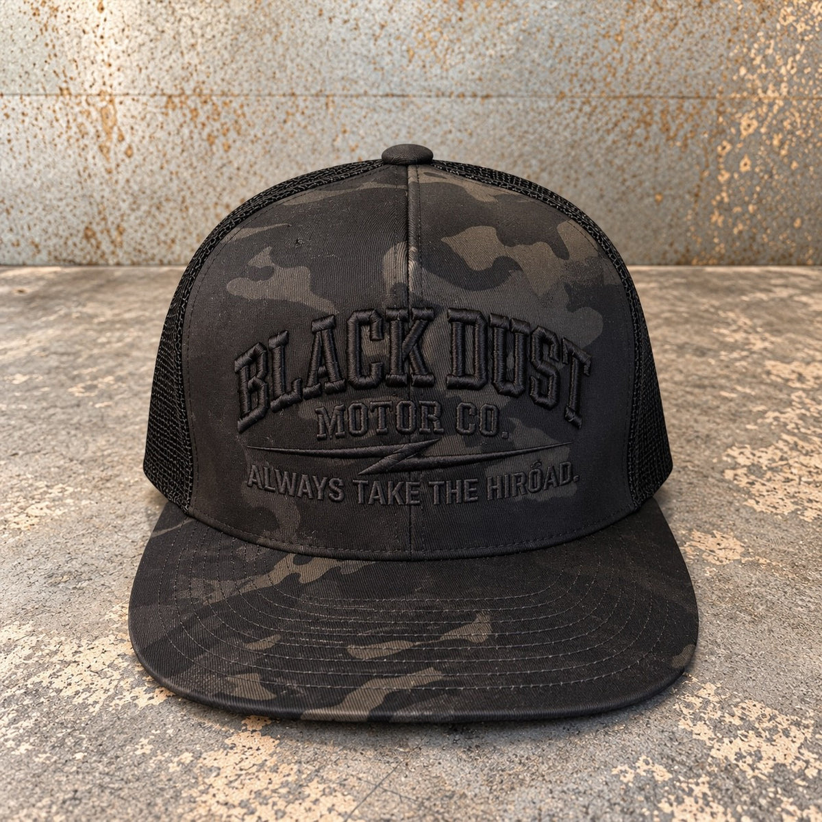 Black camo trucker hat with black mesh back and embroidered Black Dust Motor Co. logo, front