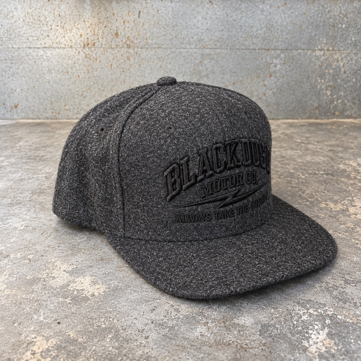 Dark charcoal wool snapback, three-quarter view