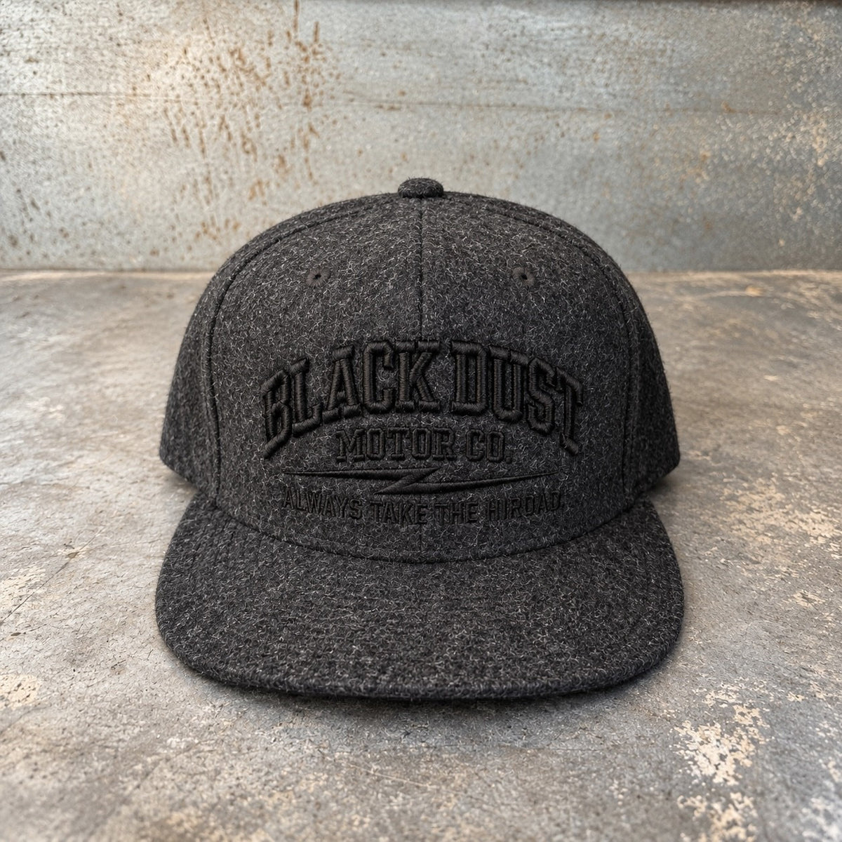 Dark charcoal wool snapback with black embroidered logo, front